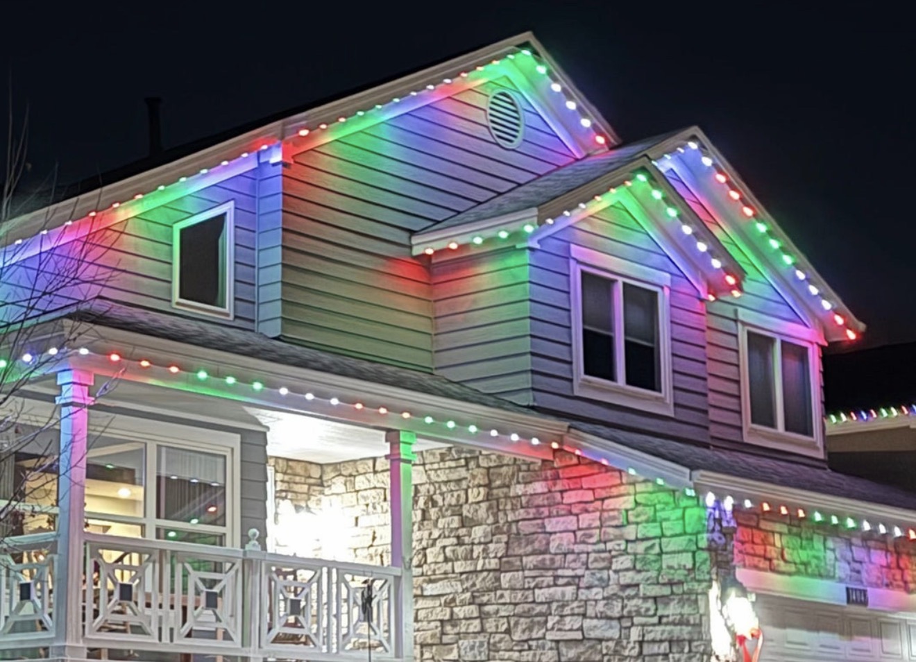 Residential exterior illuminated in red green and white permanent lighting
