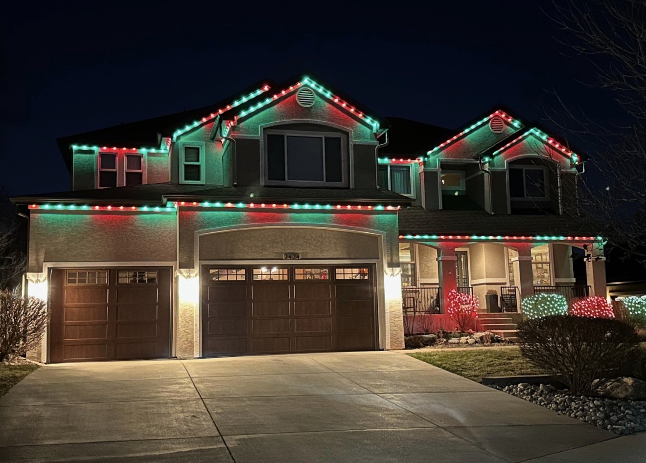 Large home with coordinated red and green permanent holiday lighting